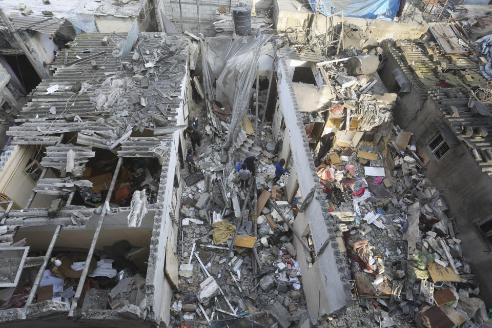 Palestinians salvage belongings after an Israeli strike on residential buildings in Rafah, Gaza Strip, on Thursday, Dec. 14, 2023. (AP Photo/Hatem Ali)