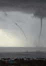 Two water spouts can be seen about a mile off shore south of downtown Honolulu Monday, May 2, 2011. (AP Photo/Eugene Tanner)