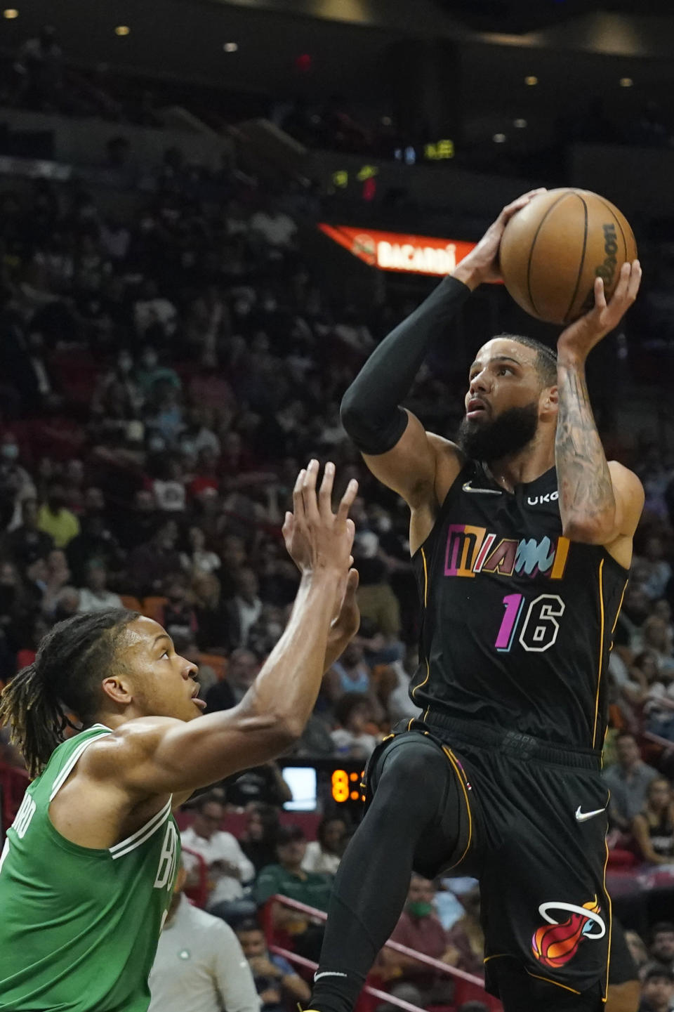 Miami Heat forward Caleb Martin (16) drives to the basket over Boston Celtics guard Romeo Langford (9) during the first half of an NBA basketball game, Thursday, Nov. 4, 2021, in Miami. (AP Photo/Marta Lavandier)