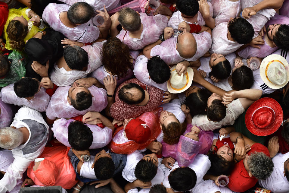 Revelers fill the town hall square celebrating the launch of the 'Chupinazo' rocket, to mark the official opening of the 2022 San Fermin fiestas in Pamplona, Spain, Wednesday, July 6, 2022. The blast of a traditional firework opened Wednesday nine days of uninterrupted partying in Pamplona's famed running-of-the-bulls festival which was suspended for the past two years because of the coronavirus pandemic. (AP Photo/Alvaro Barrientos)