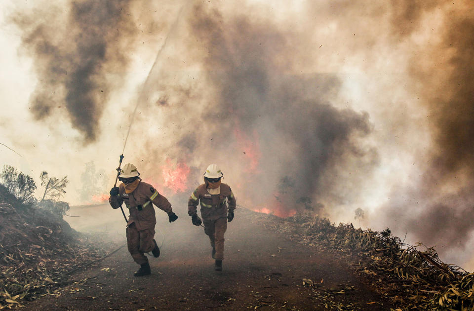 Firefighters running along road