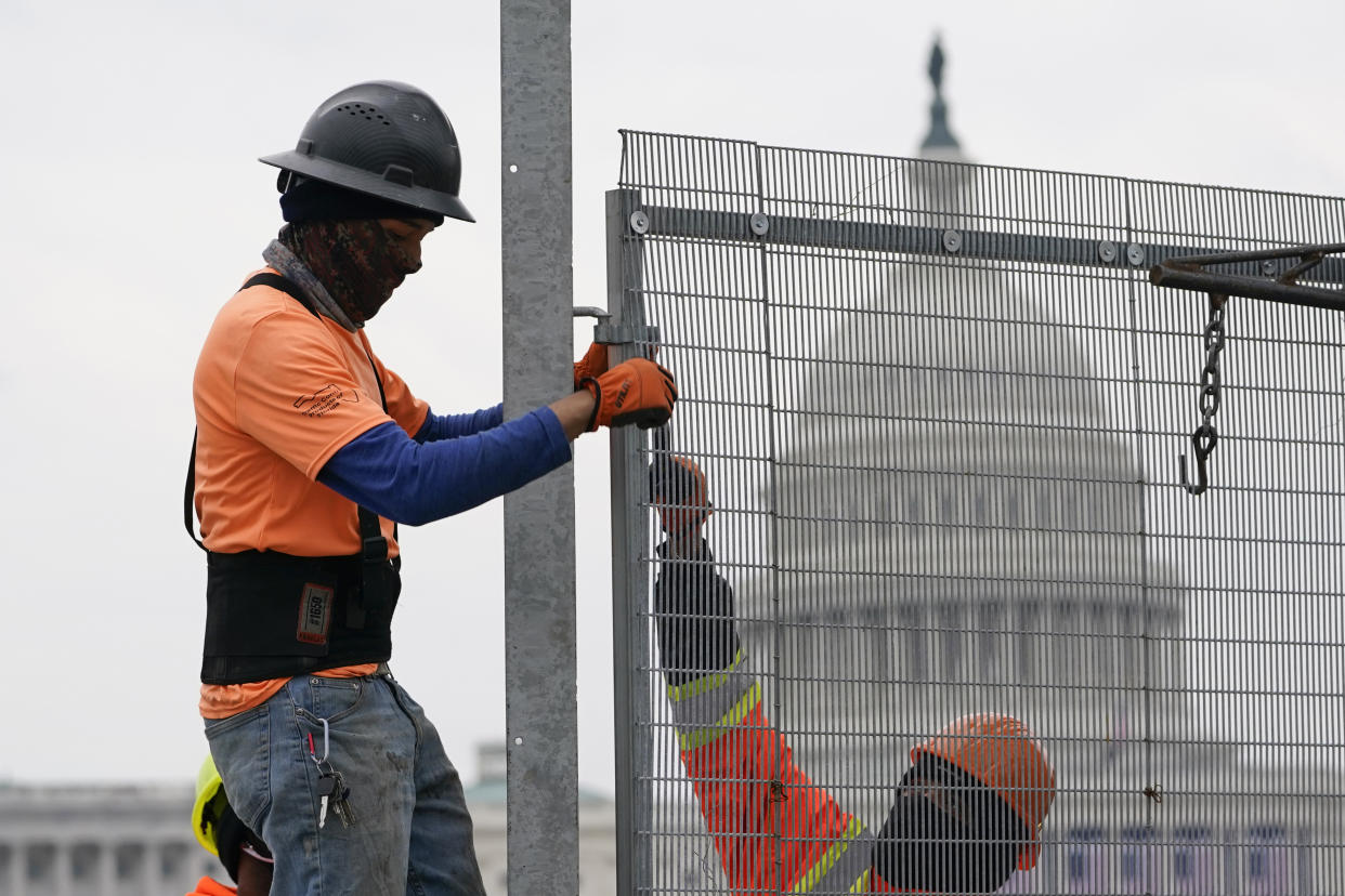 Workers install security fencing near the U.S. Capitol in Washington, Friday, Jan. 15, 2021, ahead of the inauguration of President-elect Joe Biden and Vice President-elect Kamala Harris. (AP Photo/Susan Walsh)