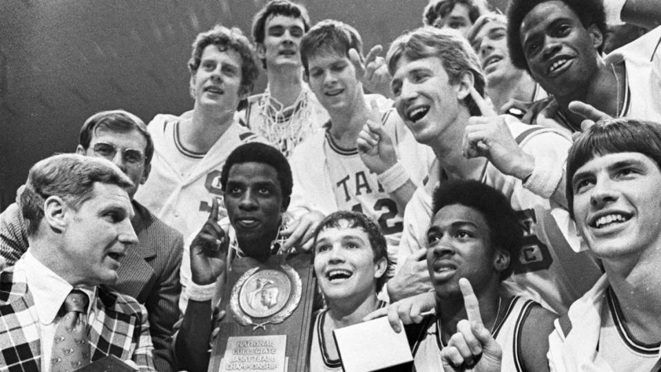 The 1974 NC State basketball team celebrates with the National Championship trophy after defeating Marquette.