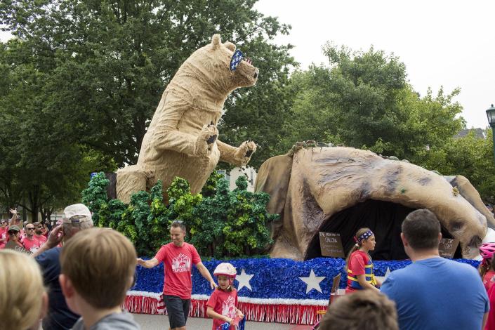 A mechanical bear rises up from its rock on a float in the 2019 Upper Arlington Fourth of July parade.
