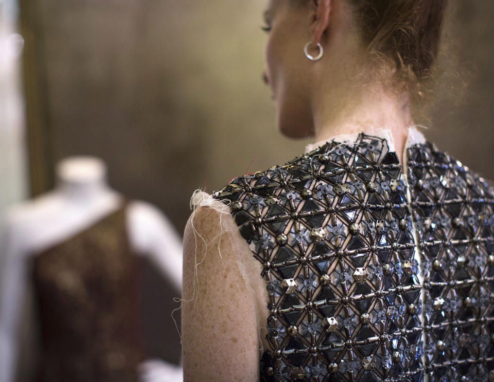 In this Aug. 30, 2013 photo, Taylor Foster, the model of fashion designer Carmen Marc Valvo, models a partially made dress at Valvo's New York studio. Valvo will show his Spring 2014 collection on Sept. 6 at Lincoln Center in New York. (AP Photo/John Minchillo)