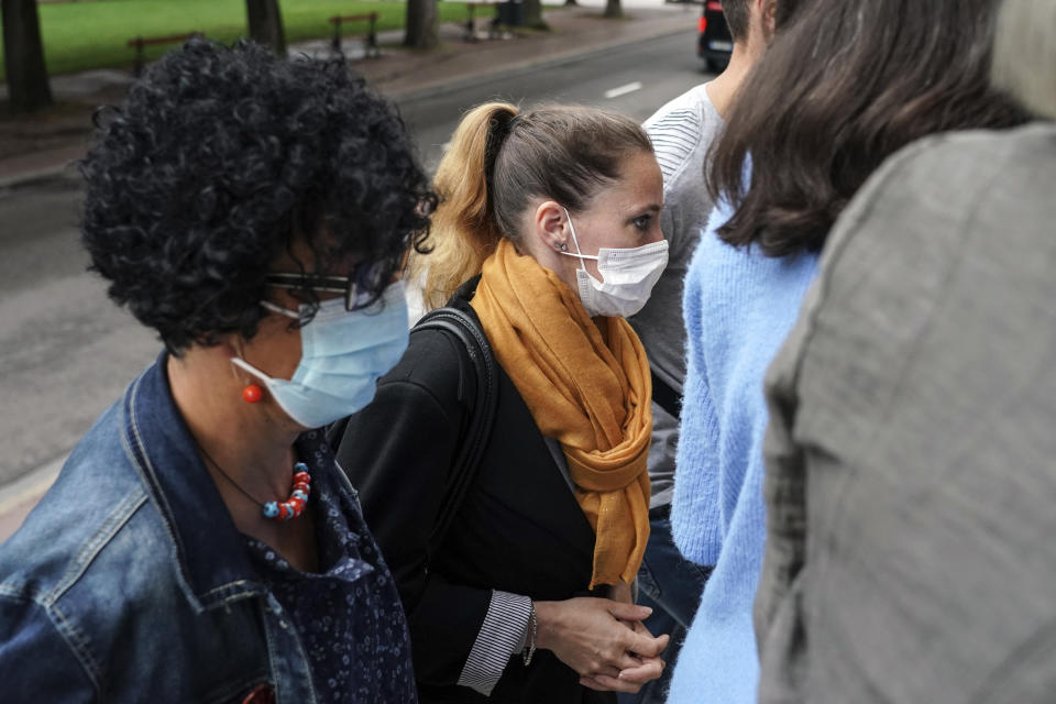 Valerie Bacot, center, arrives with relatives at the Chalon-sur-Saone courthouse, central France, Thursday, June 24, 2021. Valerie Bacot is on trial in France for killing her husband after decades of sexual, physical and psychological abuse starting when she was an adolescent, in a case that has drawn broad attention and support for Bacot amid a national reckoning with long-held taboos around domestic abuse. (AP Photo/Laurent Cipriani)