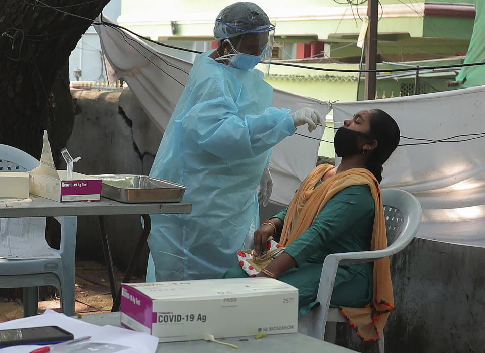 A health worker takes a nasal swab sample at a COVID-19 testing center in Hyderabad, India, Tuesday, Oct. 27, 2020. India reports 36,470 new coronavirus cases, the lowest in more than three months in a continuing downward trend. However, the overall tally neared 8 million, the second in the world behind the U.S. with over 8.7 million positive cases. (AP Photo/Mahesh Kumar A.)