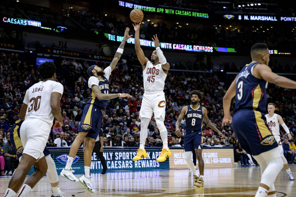 Cleveland Cavaliers guard Donovan Mitchell (45) shoots against New Orleans Pelicans forward Brandon Ingram (14) during the second half of an NBA basketball game in New Orleans, Wednesday, March 13, 2024. (AP Photo/Matthew Hinton)