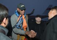 Retired U.S. basketball star Dennis Rodman (2nd L) shakes hands with officials upon arrival at Pyongyang airport, in this photo taken by Kyodo December 19, 2013. Rodman said on Thursday he was not going to North Korea to talk about politics or human rights, despite political tension surrounding the execution of leader Kim Jong Un's uncle. Mandatory credit. (REUTERS/Kyodo)