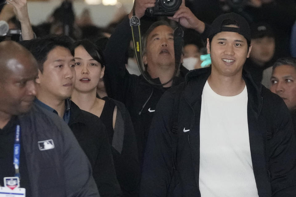 Los Angeles Dodgers' Shohei Ohtani, front right, and his wife Mamiko Tanaka walk with security during the baseball team's arrival at Incheon International Airport, Friday, March 15, 2024, in Incheon, South Korea, ahead of the team's baseball series against the San Diego Padres. (AP Photo/Lee Jin-man)