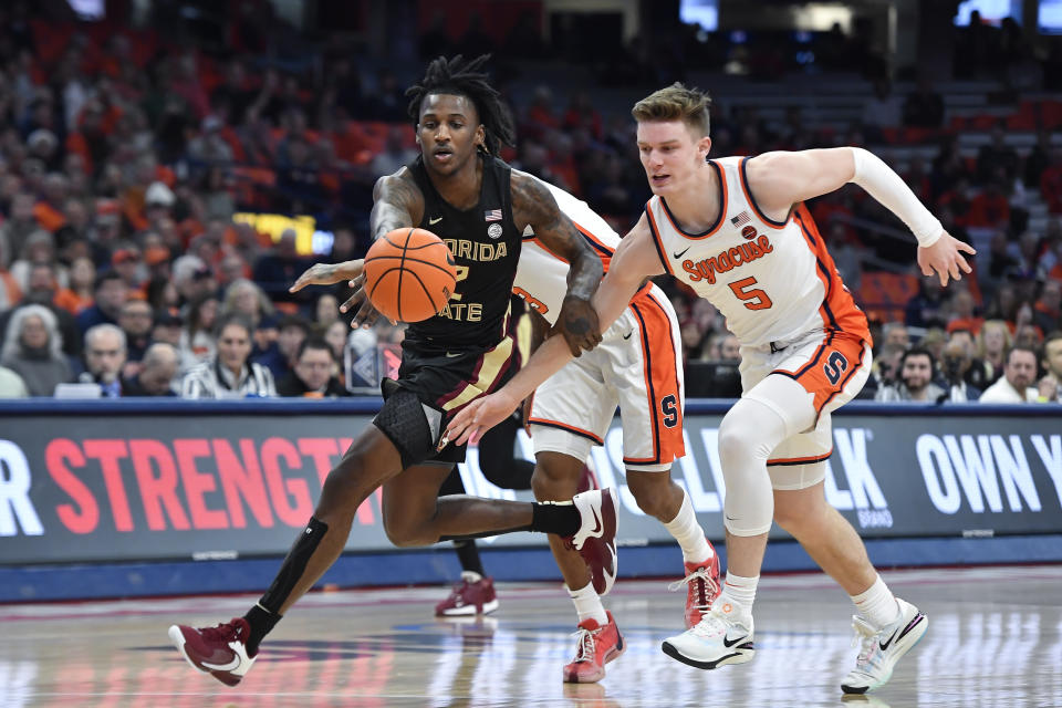 Florida State forward Jamir Watkins, left, is defended by Syracuse guard Justin Taylor during the first half of an NCAA college basketball game in Syracuse, N.Y., Tuesday, Jan. 23, 2024. (AP Photo/Adrian Kraus)