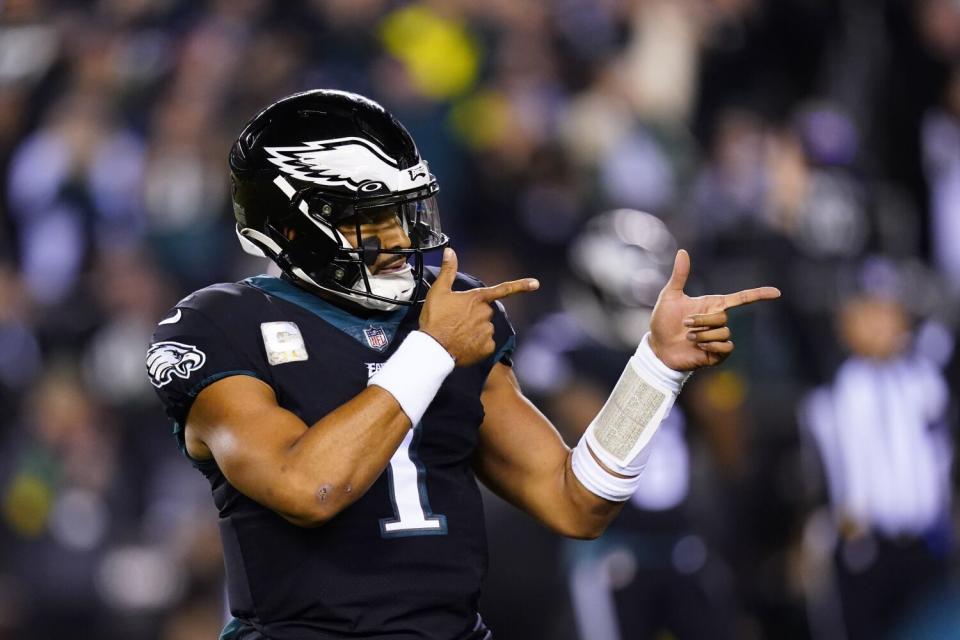 Philadelphia Eagles quarterback Jalen Hurts points with both hands as he celebrates a touchdown run by Kenneth Gainwell.