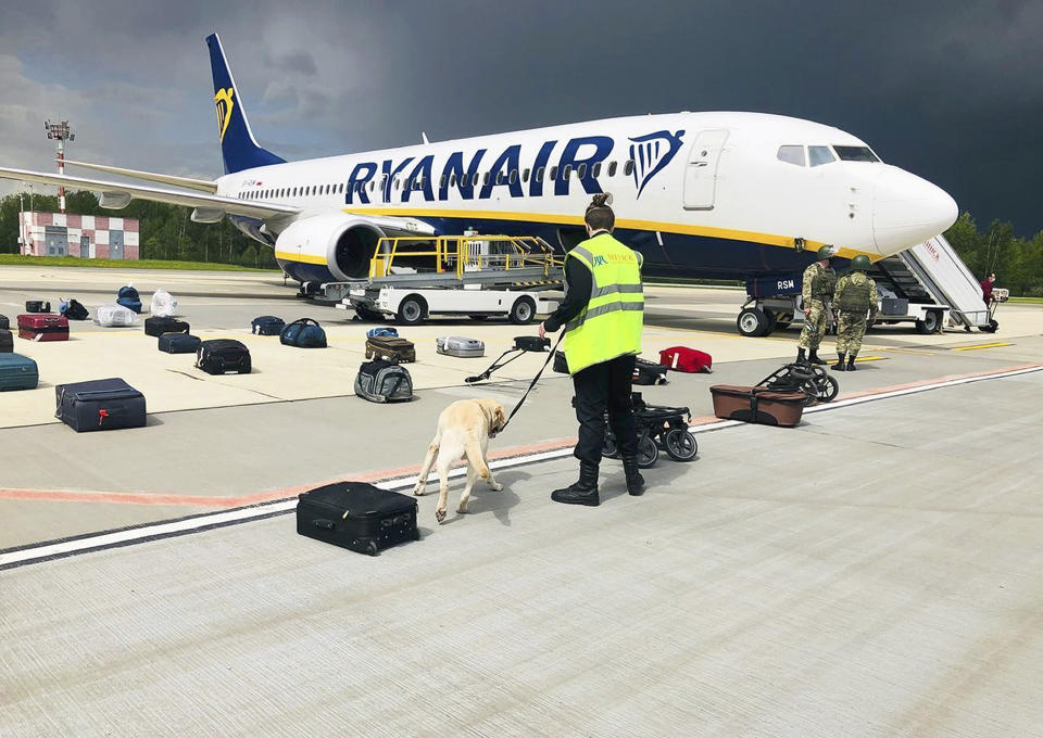 FILE - In this May 23, 2021, file photo provided by ONLINER.BY, security use a dog to check the luggage of passengers on the Ryanair jet that carried opposition figure Raman Pratasevich, traveling from Athens to Vilnius, Lithuania. The plane was diverted to Minsk, Belarus, after Belarusian flight controllers told the crew that there was a bomb threat against the plane. Pratasevich, who ran a channel on a messaging app used to organize demonstrations against authoritarian President Alexander Lukashenko, left his homeland in 2019 to try to escape the reach of the Belarusian KGB. Pratasevich was arrested upon landing in Minsk and faces 15 years in prison on charges of inciting disturbances. (ONLINER.BY via AP)