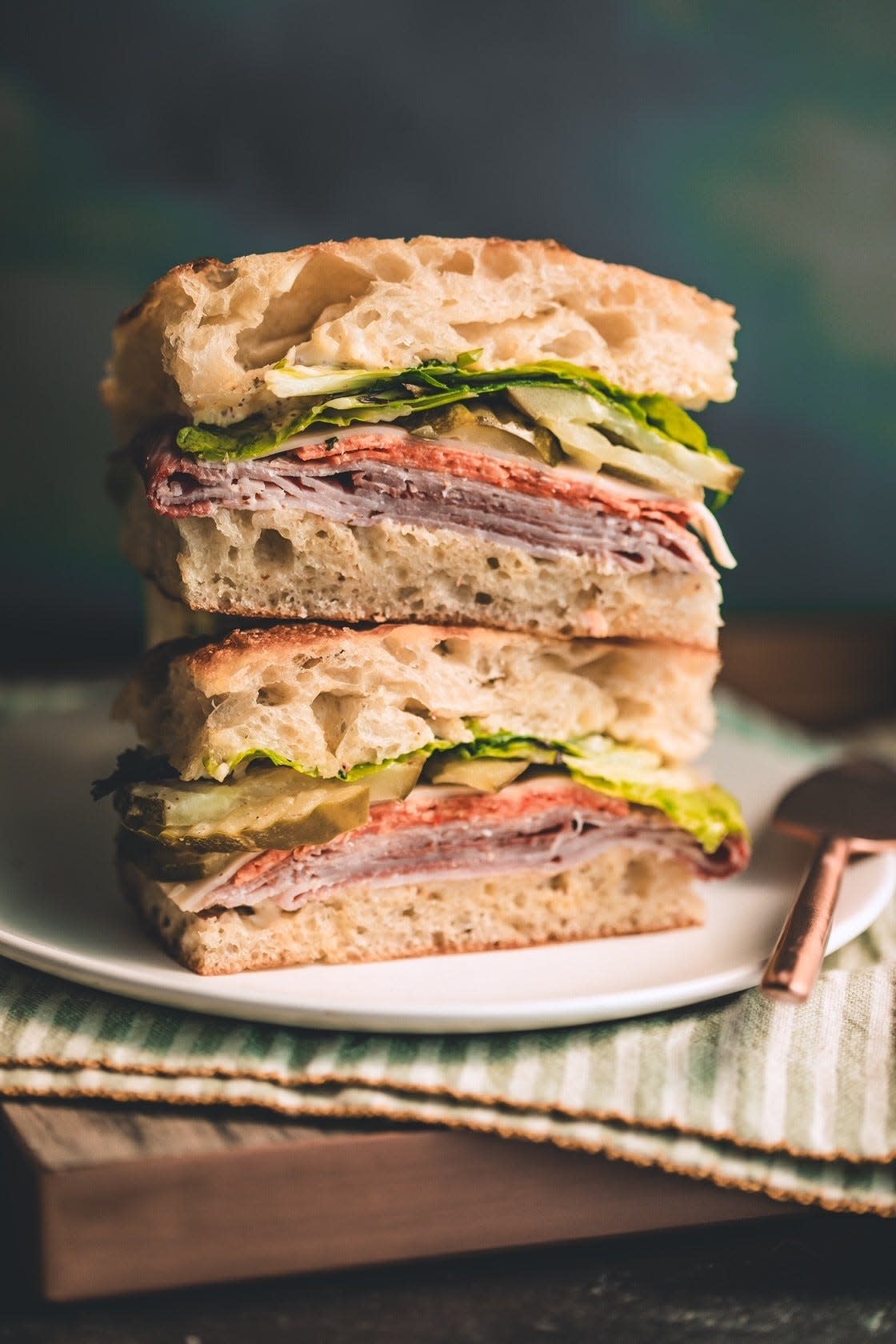 Flour's Italian focaccia sandwich made with ham, salami, Caciocavallo, house pickles, cherry peppers, greens and red wine vinaigrette.