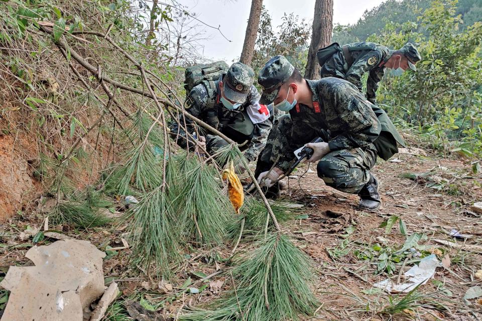 This photo taken on March 21, 2022 shows paramilitary police officers conducting a search at the site of the China Eastern Airlines plane crash in Tengxian county, Wuzhou city, in China's southern Guangxi region.