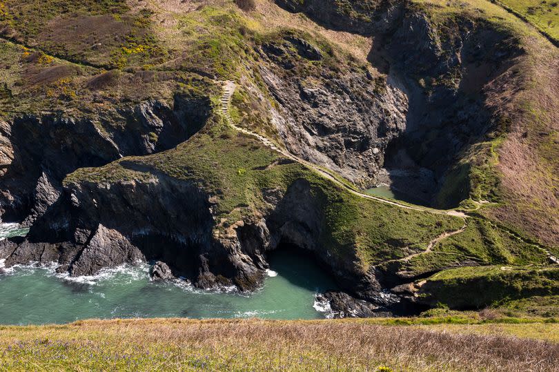 A collapsed sea cave beside a small rocky cove with high cliffs at Witches Cauldron -Credit:Getty/ ©2019 R A Kearton