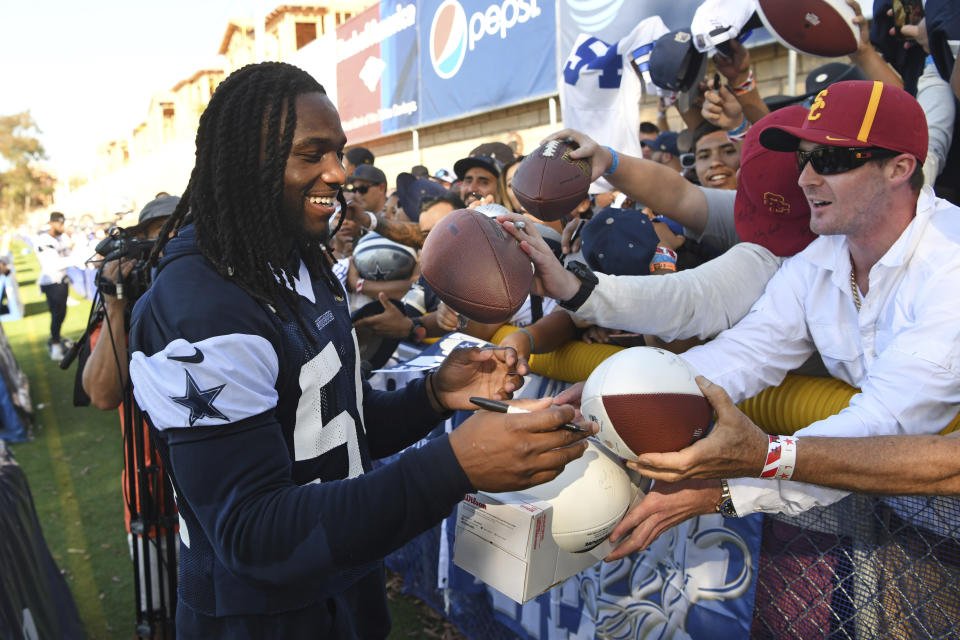 Dallas Cowboys linebacker Jaylon Smith, left, gives autographs to fans at the team's training camp in Oxnard, Calif. last year. (AP Photo/Michael Owen Baker)