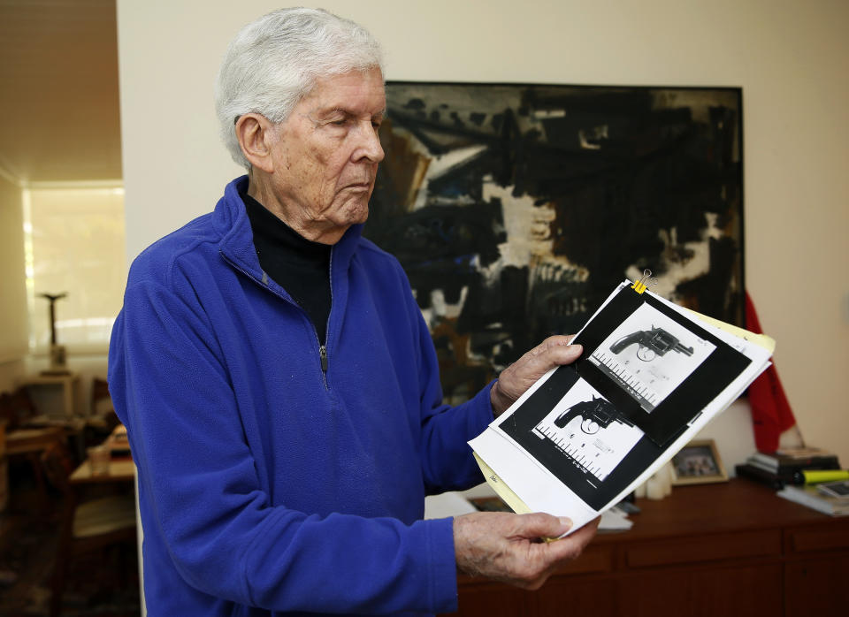 FILE - Sen. Robert Kennedy aide Paul Schrade holds an evidence photo of gunman Sirhan Sirhan's revolver with the eight expended shell casings found in the chamber, and the Weisel, Goldstein, and Kennedy bullets, at his home in Los Angeles on May 31, 2018. Schrade, a labor union leader who was shot in the head during the assassination of Robert F. Kennedy and spent decades convinced that Sirhan wasn't the killer, died Wednesday, Nov. 9, 2022, of natural causes. He was 97. (AP Photo/Damian Dovarganes, File)