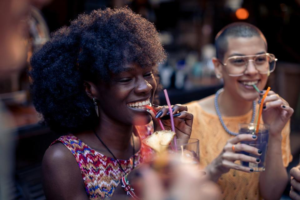 close up of two female friends enjoying drinks in a bar