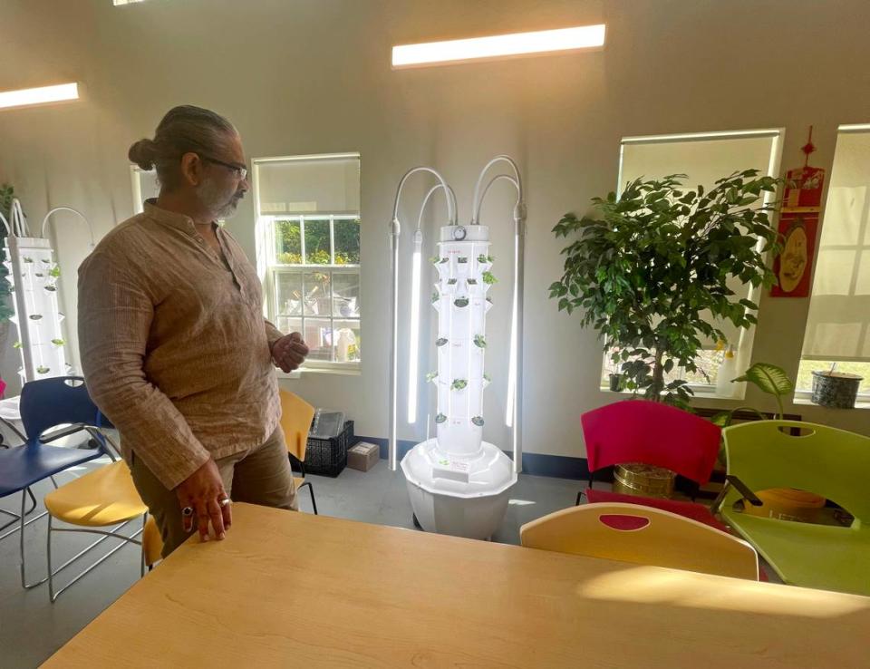 Volunteer Nimish Bhatt with indoor garden columns at the Universal Institute for Successful Aging of Carolinas. 