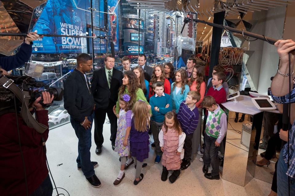 Michelle Duggar and some of her kids answering questions with a mile above them.