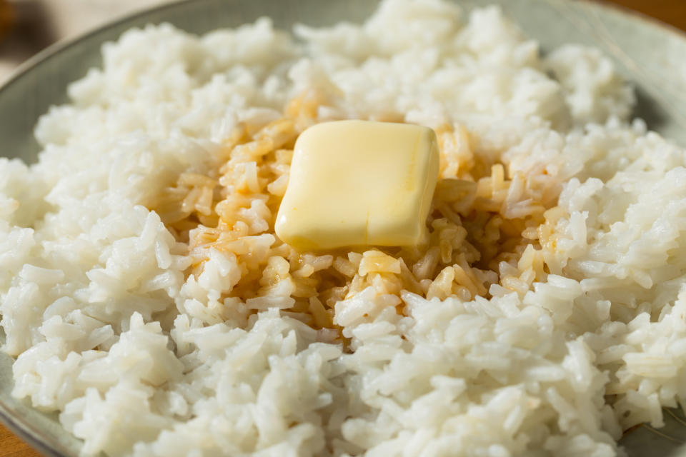 Cooked white rice topped with a melting pat of butter