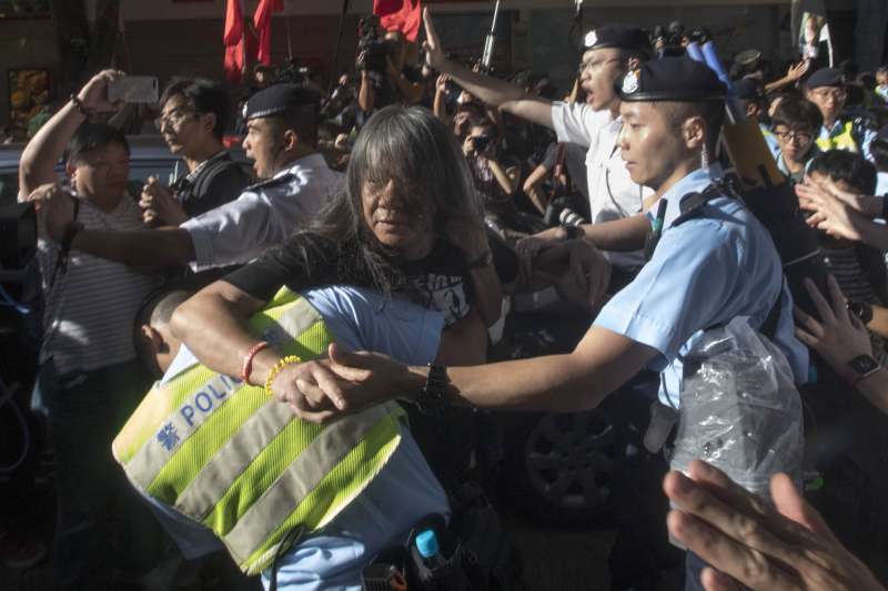 香港立法會議員「長毛」梁國雄被警方帶走。（美聯社）