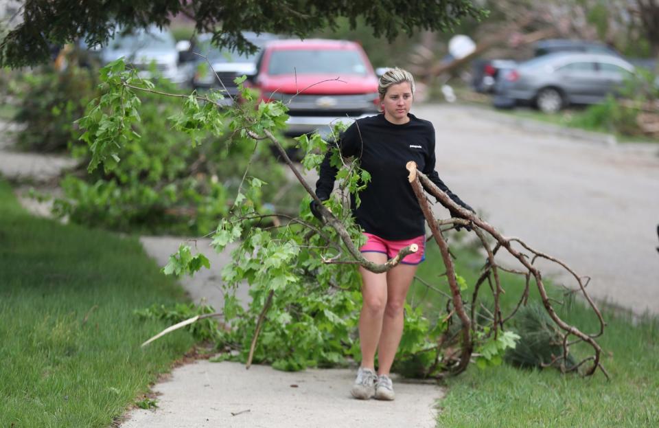 Jenna Backlund hauls away downed tree branches from her mother-in-law's home on Petoskey street. Residents of Gaylord assess damage after a tornado hit a section of the town Saturday, May 21, 2022.