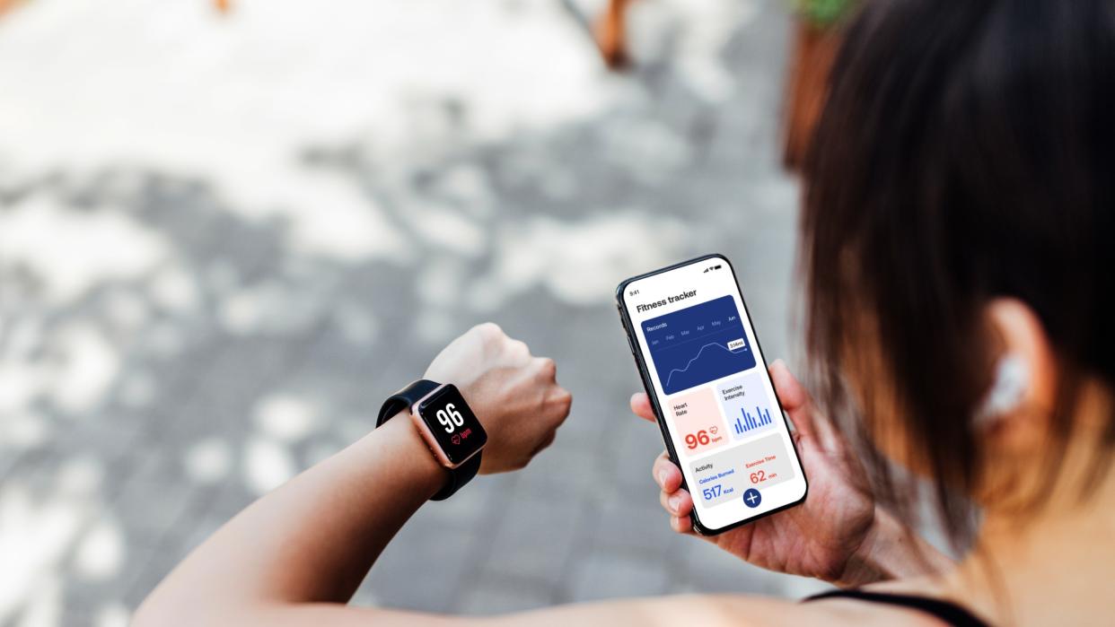  Woman using fitness tracker smart watch and app. 