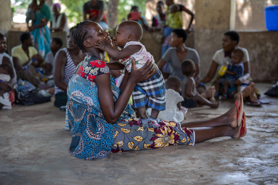 In this photo taken Wednesday, Dec. 11, 2019, residents of the Malawi village of Tomali wait to have their young children become test subjects for the world's first vaccine against malaria. Babies in three African nations are getting the first and only vaccine for malaria in a pilot program. World health officials want to see how well the vaccine works in Malawi, Ghana and Kenya before recommending its wider use. (AP Photo/Jerome Delay)