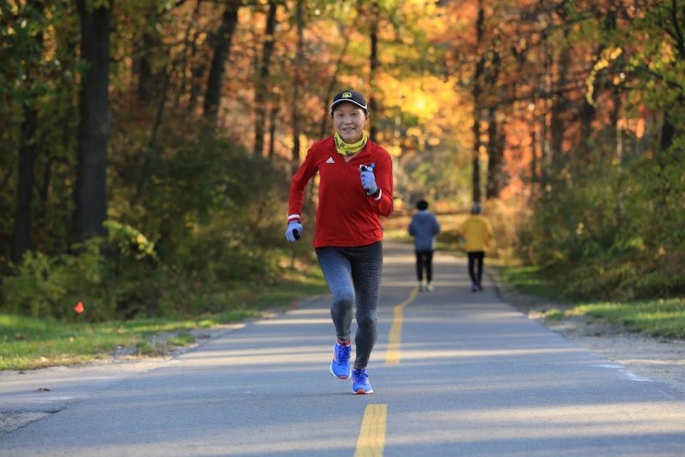 Jin Zhu of Farmington Hills runs the paved path at Kensington Metropark in Milford in fall 2022, training for marathons and ultra-marathons.