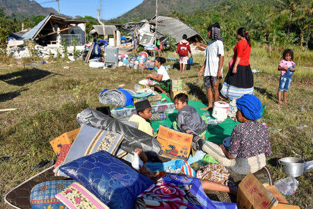 Residents sit outside their home with their belongings following a strong earthquake in Pemenang, North Lombok, Indonesia August 6, 2018 in this photo taken by Antara Foto. Antara Foto/Ahmad Subaidi/ via REUTERS