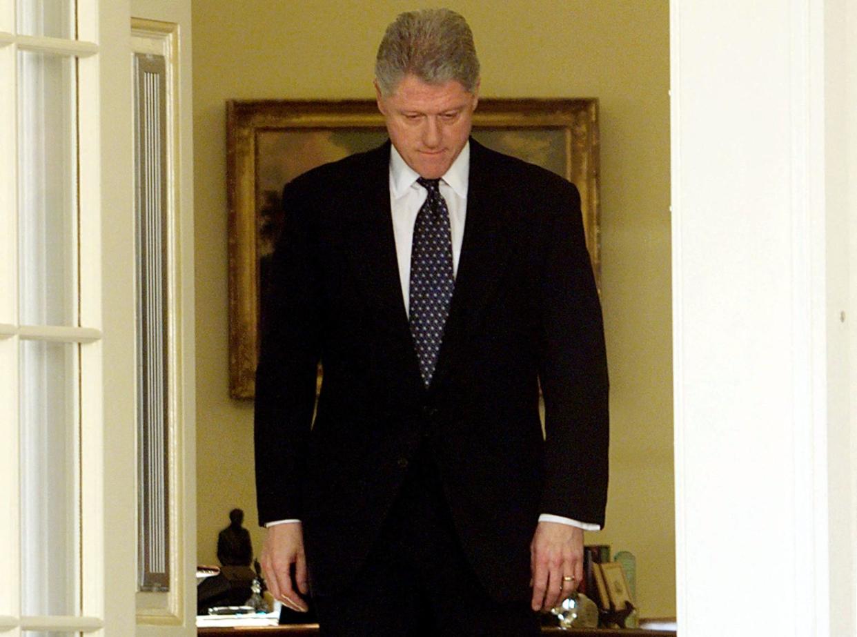 US President Bill Clinton walks through the doors of the Oval Office moments before reading a statement in the Rose Garden of the White House after the Senate voted not to impeach him 12 February in Washington, DC. Clinton apologized for the actions that led to his impeachment and subsequent acquittal by the Senate, saying he was 