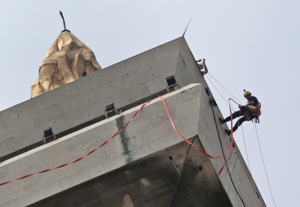 In this Thursday, May 8, 2014 photo, a worker rappels down from the top of the National Monument to prepare for its cleaning in Jakarta, Indonesia. German-based Kaercher company, which specializes in the cleaning of cultural monuments, is doing the work. It also did the monument’s last cleaning in 1992. The 132-meter (433-feet) tall monument, a popular landmark in the capital, is being cleaned for the first time in more than two decades. (AP Photo/Dita Alangkara)