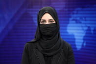 Khatereh Ahmadi a TV anchor reads news on TOLO NEWS studio while covering her face, in Kabul, Afghanistan, Sunday, May 22, 2022. Afghanistan's Taliban rulers have begun enforcing an order requiring all female TV news anchors in the country to cover their faces while on-air. The move Sunday is part of a hard-line shift drawing condemnation from rights activists. (AP Photo/Ebrahim Noroozi)