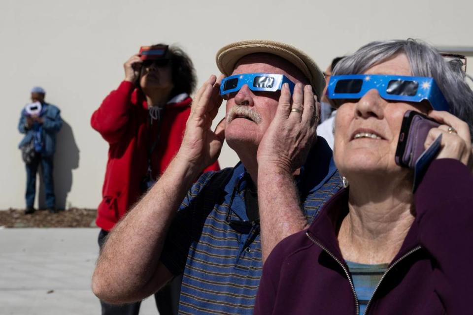 David and Colleen McManus of Elk Grove wear solar eclipse glasses to view the eclipse at the Museum of Science and Curiosity in Sacramento on Monday, April 8, 2024.