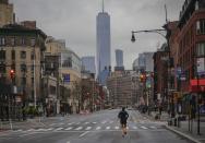 A lone jogger run on a partially empty 7th Avenue, resulting from citywide restrictions calling for people to stay indoors and maintain social distancing in an effort to curb the spread of COVID-19, Saturday March 28, 2020, in New York. President Donald Trump says he's considering a quarantine affecting residents of the state and neighboring New Jersey and Connecticut amid the coronavirus outbreak, but New York Gov. Andrew Cuomo said that roping off states would amount to "a federal declaration of war." (AP Photo/Bebeto Matthews)