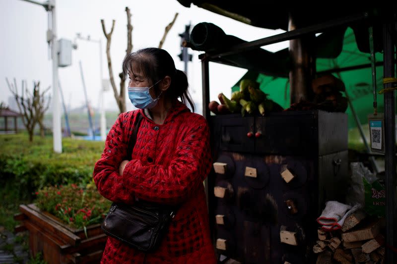 Li Yu wears a face mask at an ancient city wall in Jingzhou, after the lockdown was eased in Hubei