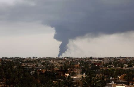 Plumes of smoke rise in the sky after a rocket hit a fuel storage tank near the airport road in Tripoli, during clashes between rival militias July 28, 2014. REUTERS/Ismail Zitouny