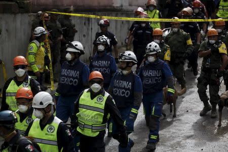 Rescue workers walk towards an area affected by a mudslide in Santa Catarina Pinula, on the outskirts of Guatemala City, October 5, 2015. REUTERS/Jose Cabezas