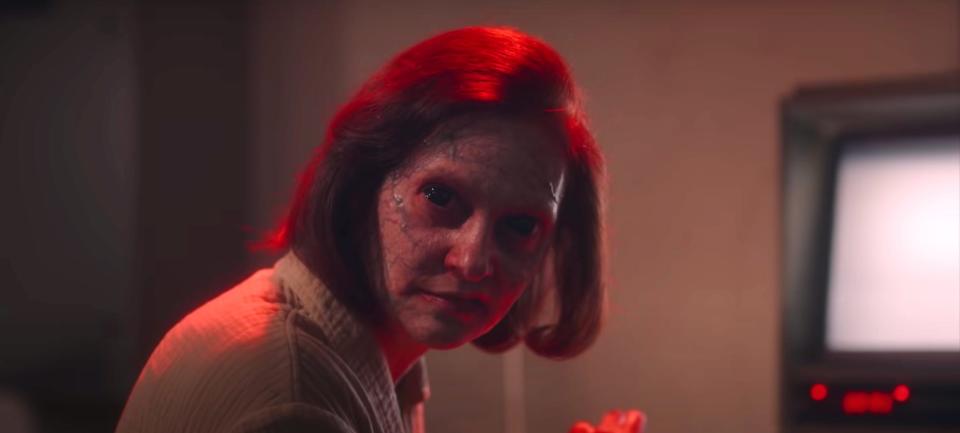 A mutated woman with short hair looks at the viewer in this still from "American Horror Stories."