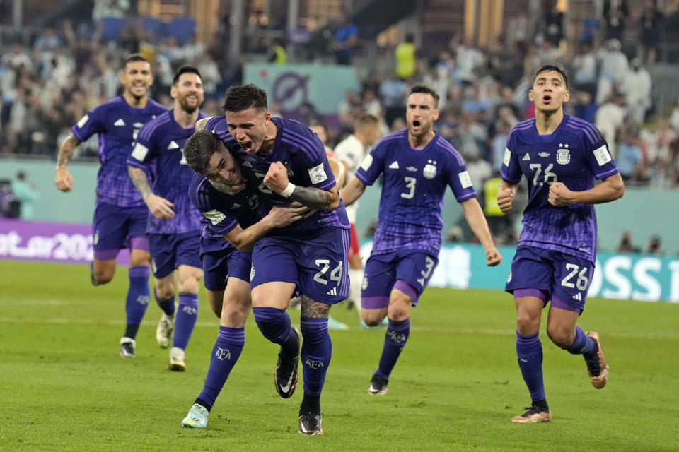 Argentina's Julian Alvarez, front left, is embraced by teammate Enzo Fernandez (24) after scoring a goal during the World Cup group C soccer match between Poland and Argentina at the Stadium 974 in Doha, Qatar, Wednesday, Nov. 30, 2022. (AP Photo/Natacha Pisarenko)