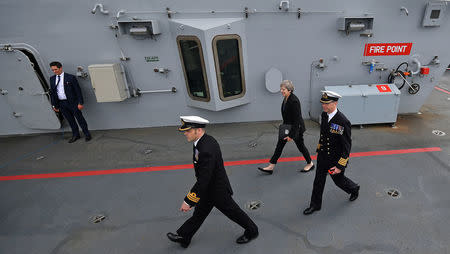 Commodore Jerry Kyd walks with Britain's Prime Minister Theresa May during her tour of the British aircraft carrier HMS Queen Elizabeth, after it arrived at Portsmouth Naval base, its new home port, in Portsmouth, Britain August 16, 2017. REUTERS/Ben Stansall/Pool