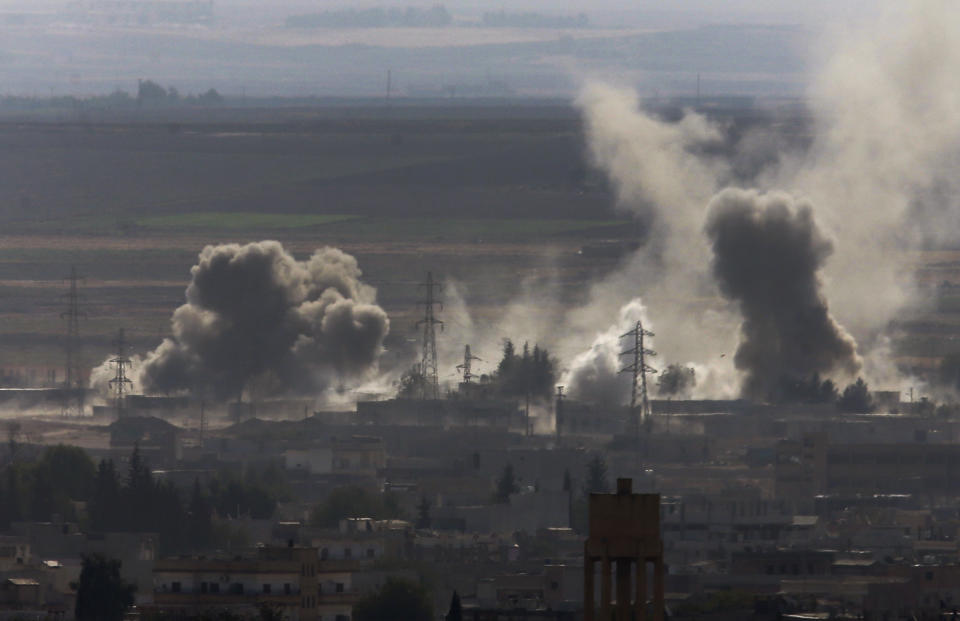 In this photo taken from the Turkish side of the border between Turkey and Syria, in Ceylanpinar, Sanliurfa province, southeastern Turkey, smoke and dust billows from targets in Ras al-Ayn, Syria, caused by bombardment by Turkish forces, Tuesday, Oct. 15, 2019. Turkish artillery on Tuesday pounded suspected Syrian Kurdish positions near the town in northeast Syria amid reports that Kurdish fighters had retaken the town as Turkey pressed ahead with a military incursion that has drawn widespread condemnation. (AP Photo/Lefteris Pitarakis)