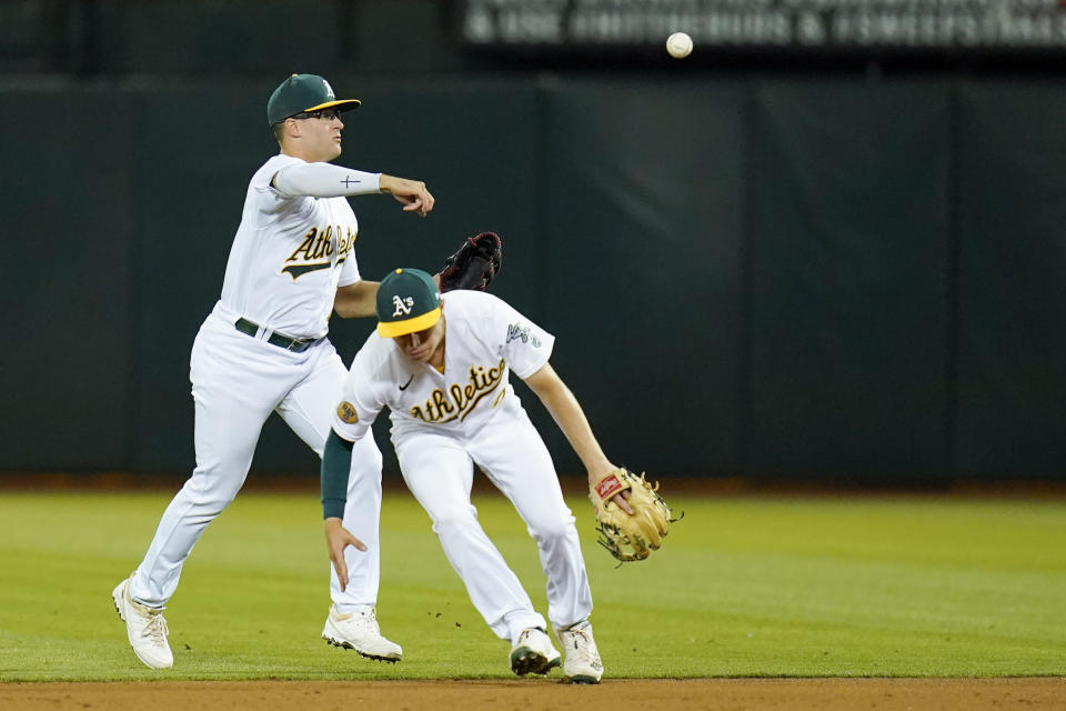 Oakland Athletics shortstop Nick Allen, right, ducks as second baseman Jonah Bride, left, throws to first base for an out against Miami Marlins' Lewin Díaz during the sixth inning of a baseball game in Oakland, Calif., Monday, Aug. 22, 2022. (AP Photo/Godofredo A. Vásquez)