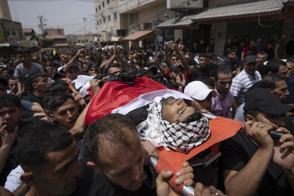 Mourners carry the body of Yahia Edwan, 27 during his funeral at the West Bank village of Azzoun, near Qalqiliya, Saturday, April 30, 2022. Israeli troops shot and killed Edwan early Saturday, the Palestinian Health Ministry said. The Israeli army said it had opened fire after a group of suspects threw firebombs toward the soldiers. (AP Photo/Nasser Nasser)