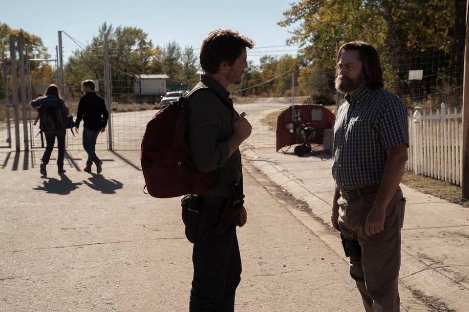 Bill (Nick Offerman) talks to Joel (Pedro Pascal) in the foreground as Tess (Anna Torv) and Frank (Murray Bartlett) chat in the background in The Last of Us.