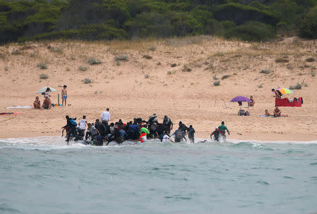 Migrants disembark from a dinghy at "Del Canuelo" beach after they crossed the Strait of Gibraltar sailing from the coast of Morocco, in Tarifa, southern Spain, July 27, 2018. REUTERS/Jon Nazca