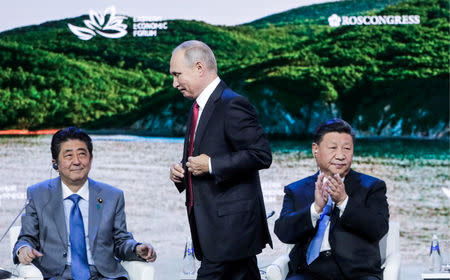 (L-R) Japanese Prime Minister Shinzo Abe, Russian President Vladimir Putin and Chinese President Xi Jinping attend a session of the Eastern Economic Forum in Vladivostok, Russia September 12, 2018. Mikhail Metzel/TASS Host Photo Agency/Pool via REUTERS