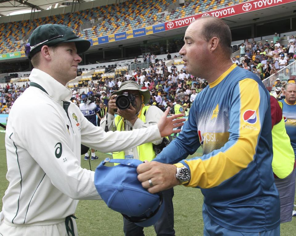 Australian captain Steve Smith shakes hands with Pakistan's coach Mickey Arthur, right, after Australia's victory on the final day of the first cricket test between Australia and Pakistan in Brisbane, Australia, Monday, Dec. 19, 2016. (AP Photo/Tertius Pickard)